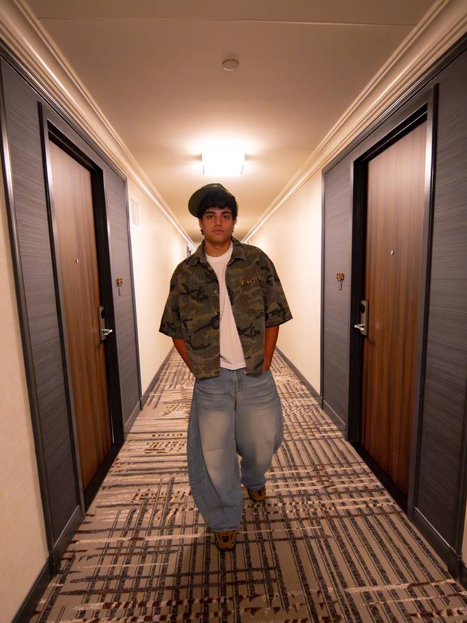 Matheus em look casual num corredor de hotel