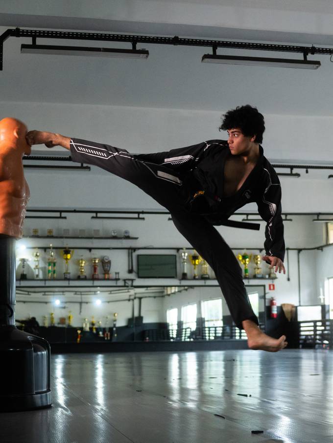 Matheus aplicando um chute alto no dojo